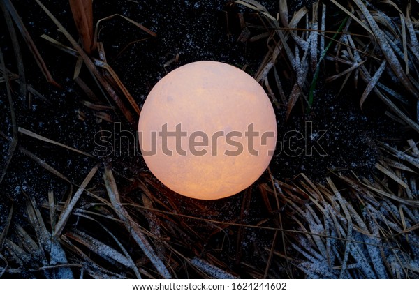 A full
moon on the ground during the evening. Lunar model, moon-shaped
lamp with moon craters            
