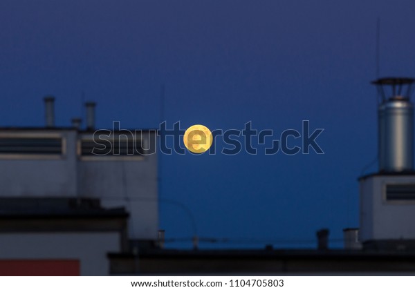 Full moon over the house\
roof