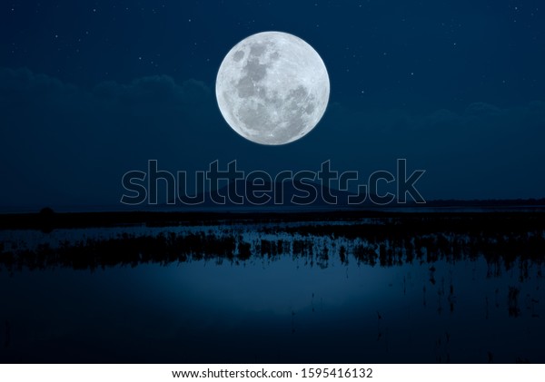 Full moon over the lake at\
night.