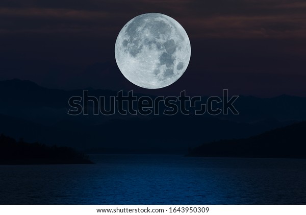 Full moon over lake at\
night.