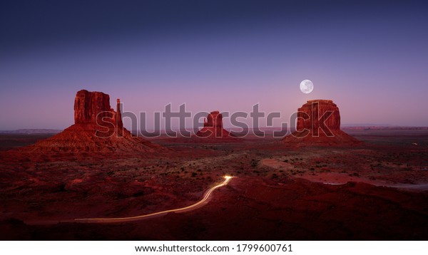 Full Moon over Monument\
Valley - with light trails from cars exiting the park.  Brilliant\
colors at dusk.