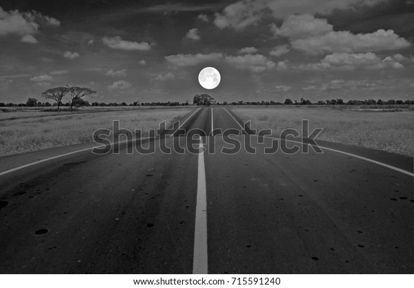 Full moon over the road\
in the field