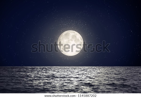 Full moon over sea\
surface with reflection