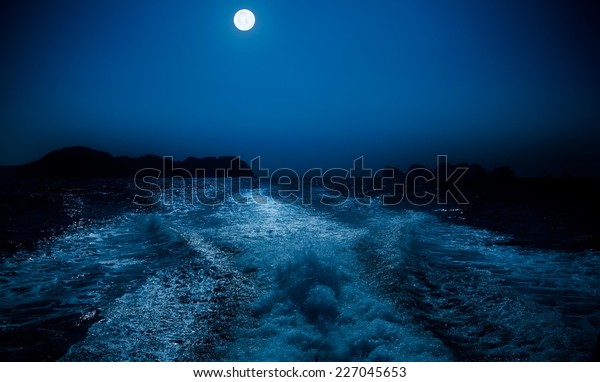 Full moon over sea\
surface.