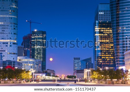 Full moon over the stunning La Defence Parisian business district bristling with skyscrapers that started life in the 1960's. Arc de triomphe visible on the horizon.