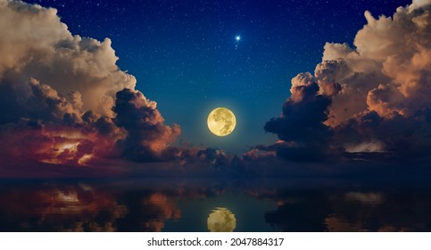 Full moon rising above serene sea in sunset sky with glowing clouds and bright stars. Elements of this image furnished by NASA