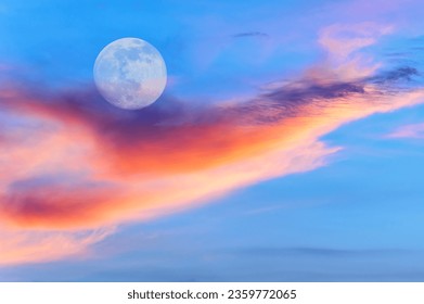 A Full Moon Is Rising In A Colorful Sunset Blue Daytime Sky