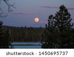 The full moon rising in the east at sunset over Thompson Reservoir, in eastern Oregon