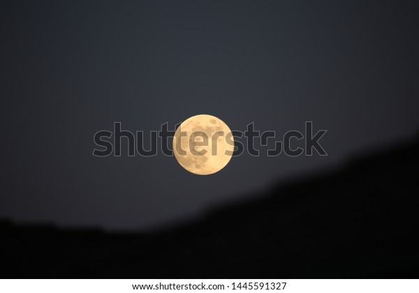 Full moon rising up on\
roofs
