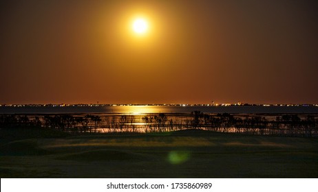 Full Moon Rising Over The High Tide On A Golf Course