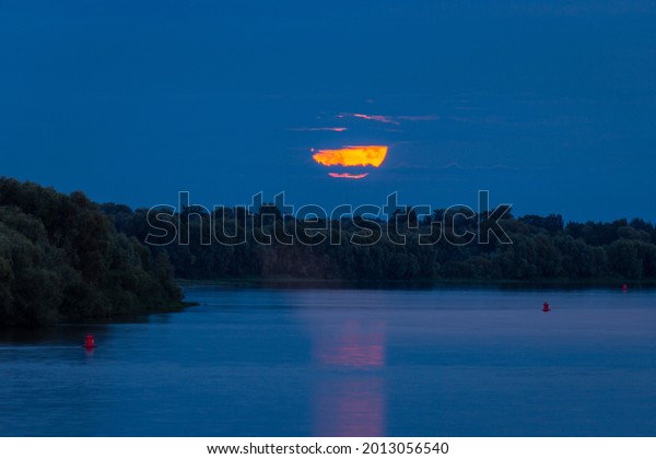 full moon rising over the river, full moon evening,\
low moon in the sky