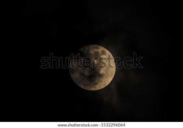 full moon\
scary night, view of full moon rising in dark sky around with dark\
clouds moving in rainy sky\
background.