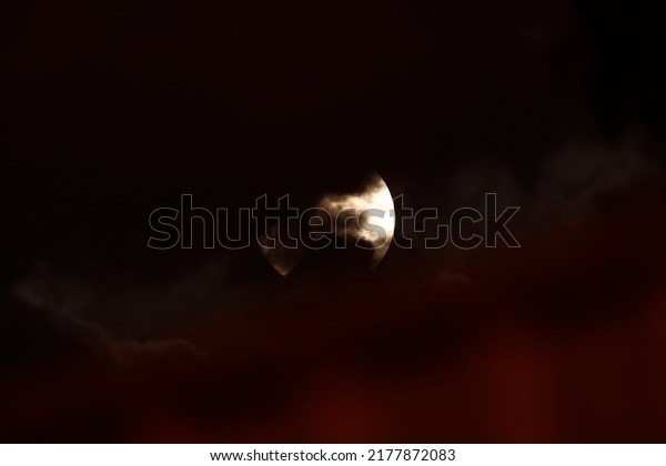 Full moon seen against an atmospheric and\
mysterious dark and red cloudy sky seen in Perth Western Australia\
on the 13th of July 2022.