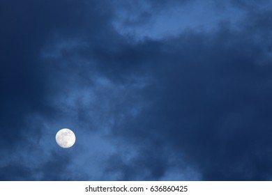 A full moon seen through clouds.