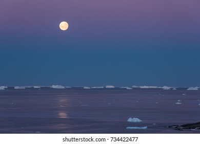 Full Moon Setting Over Ice Bergs, East Antarctica.