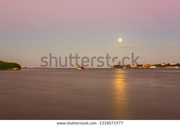 Full\
moon shine moonlight reflection in water at mactan strait cebu ,\
fisher boat in the sea running in to harbor port \
