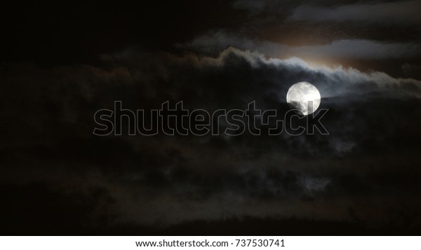 full moon shining bright as clouds move across\
the face of the moon.Dark night sky\
