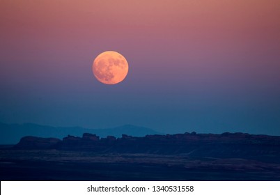 The Full Moon Or Supermoon Rises Over Monument Valley On Navajo Tribal Land On The Utah/Arizona Border.