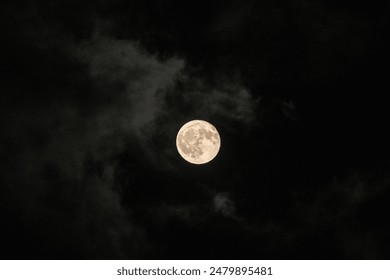 Full moon visible through the clouds