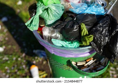 Full Over Capacity Dust Green Bin On Town Street