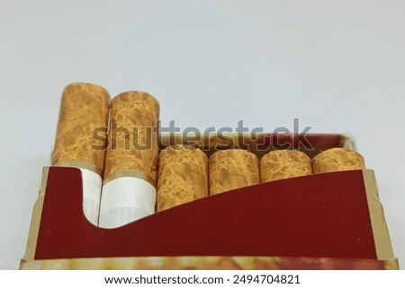 A full pack of cigarettes with the wrapper opened to reveal neat cigarette sticks. White background.