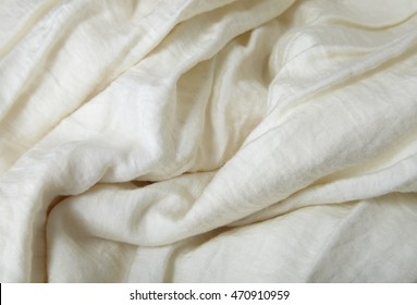 A full page close up of folds of cream colored crepe material texture