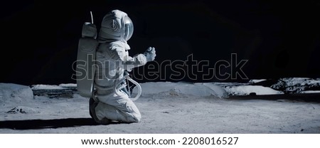Full portrait of Caucasian female lunar astronaut finds something and kneels while exploring Moon surface