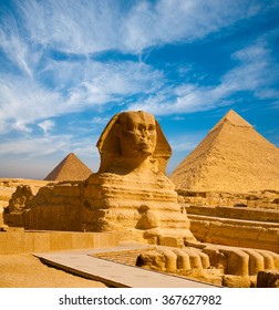 Full profile of Great Sphinx including pyramids of Menkaure and Khafre in the background on a clear sunny, blue sky day in Giza, Cairo, Egypt with no people