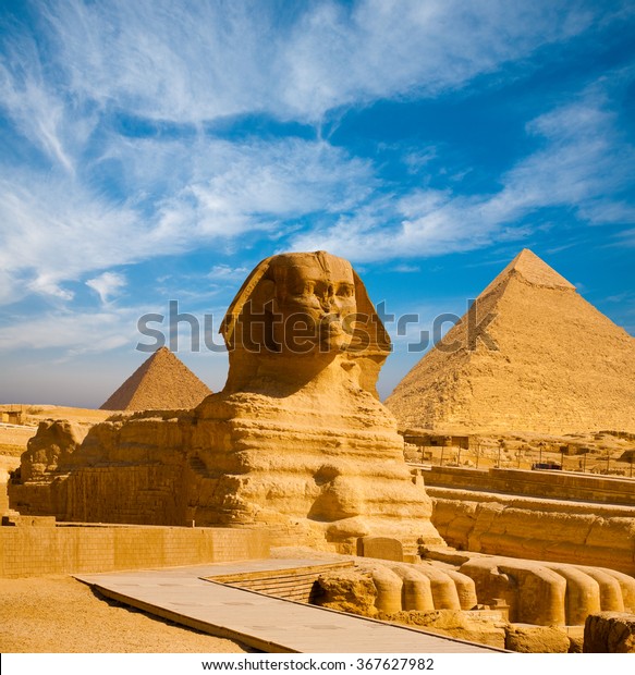 Full profile of Great Sphinx\
including pyramids of Menkaure and Khafre in the background on a\
clear sunny, blue sky day in Giza, Cairo, Egypt with no\
people