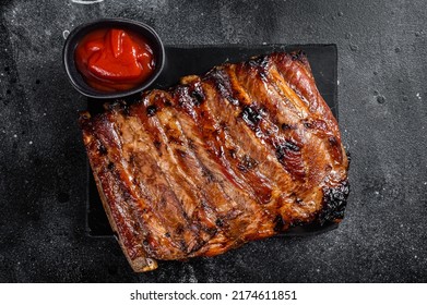 Full Rack Of BBQ Grilled Pork Spare Ribs On A Marble Board. Black Background. Top View