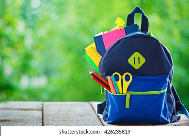 Full School Backpack On Wooden And Nature Background