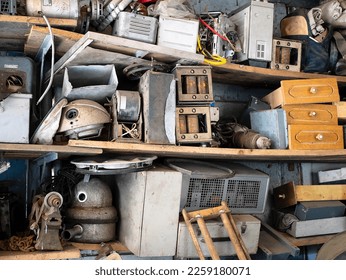 Full shelves of vintage equipment and things in abandoned garage, selective focus. Clutter, unnecessary things