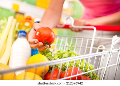 Full Shopping Cart At Store With Fresh Vegetables And Hands Close-up.