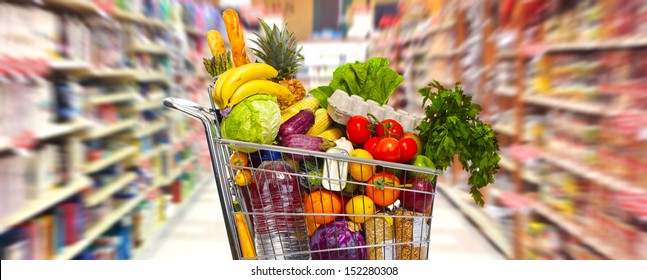 Full shopping grocery cart in supermarket.