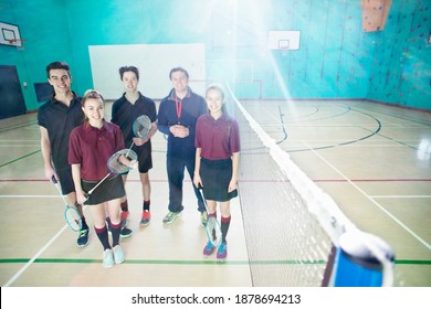 Full Shot Of A Gym Teacher And High School Students Standing Next To A Badminton Net In A Gym.