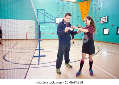 Full Shot Of A Gym Teacher Teaching Badminton To A High School Student In A Gym.