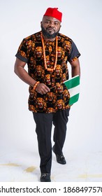 Full shot of a handsome Nigerian Igbo man carrying the Nigerian Flag