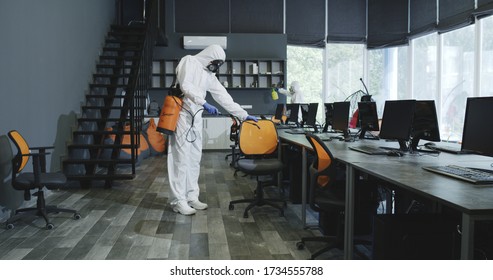 Full shot of men in hazmat suits disinfecting office - Shutterstock ID 1734555788