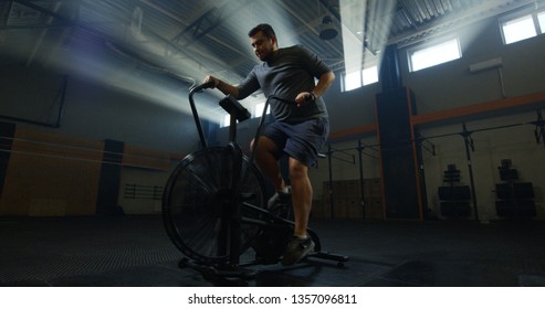 Full Shot Of An Overweight Young Man Doing An Intense Workout On An Exercise Bike