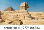 Full side view of the Great Sphinx of Giza with the Pyramid of Khafre in the background, archaeological plateau under bright sunlight, Egypt