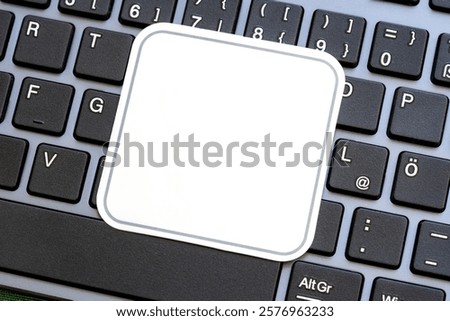Full simple blank white square label on a laptop computer keyboard, empty sticker template for logo design, closeup detail, modern business tech startup branding logo copy space concept, nobody
