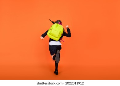 Full Size Back View Photo Of Young Girl Hold Rucksack Go Run Hurry School Lesson Isolated Over Orange Color Background