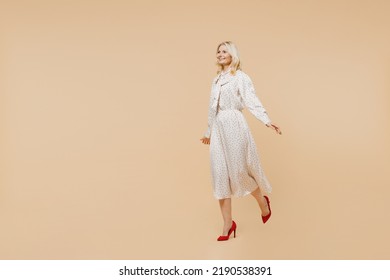 Full Size Body Length Beautiful Smiling Active Happy Elderly Gray-haired Blonde Woman Lady 40s Years Old Wears Pink Dress Go Move Run Hurry Up Isolated On Plain Pastel Beige Background Studio Portrait