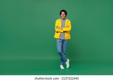 Full Size Body Length Cheerful Happy Fun Blithesome Young Black Curly Man 20s Years Old Wears Yellow Waterproof Raincoat Outerwear Hold Hands Crossed Isolated On Plain Green Background Studio Portrait