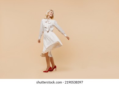 Full size body length cheerful playful elderly gray-haired blonde woman lady 40s years old wears pink dress whirl dance have fun rest relax isolated on plain pastel beige background studio portrait - Powered by Shutterstock