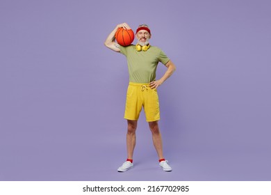 Full Size Body Length Confident Fun Elderly Gray-haired Bearded Man 50s Years Old In Headband Khaki T-shirt Hold Basketball On Shoulder Isolated On Plain Pastel Light Purple Background Studio Portrait