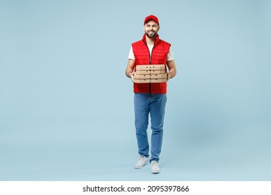 Full Size Body Length Delivery Employee Man In Red Cap White T-shirt Vest Uniform Work Dealer Courier Hold Pizza In Cardboard Flatbox Isolated On Pastel Blue Color Background Studio. Service Concept