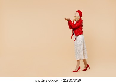 Full Size Body Length Elderly Gray-haired Blonde Woman Lady 40s Years Old Wears Red Beret Jacket Dress Go Move Run Blowing Sending Air Kiss Isolated On Plain Pastel Beige Background Studio Portrait