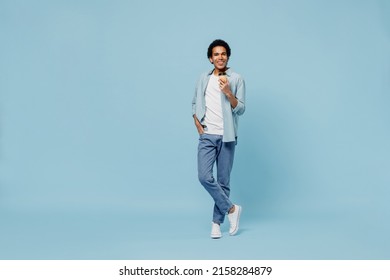 Full Size Body Length Fun Young Black Curly Man 20s Years Old Wears White Shirt Hold Takeaway Delivery Craft Paper Brown Cup Coffee To Go Isolated On Plain Pastel Light Blue Background Studio Portrait