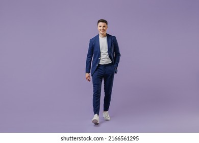 Full size body length happy young successful employee business man lawyer 20s wear formal blue suit white t-shirt work in office move hand in pocket isolated pastel purple background studio portrait - Powered by Shutterstock